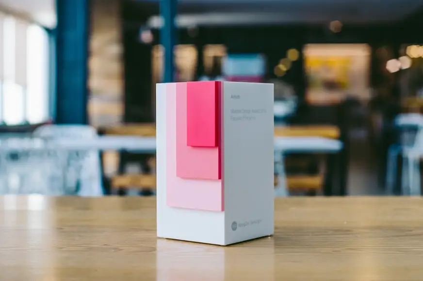 Airbnb Material Design Award trophy with layered pink panels on a wooden table